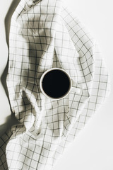 Coffee cup on white blanket. Flat lay, top view.