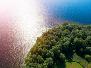 Naklejka na ściany i meble Aerial view of seashore with beach, lagoons and coral reefs. Coastline with sand and water. Tropical landscape. Aerial photography. Birdseye. Sea, beach, sky, clouds.