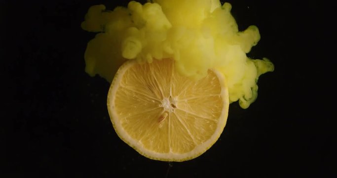Explosion effect of colors on a lemon frying in the air on a black background. Concept: fruit, colors, special effect
