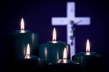 Lit candles on a white cross