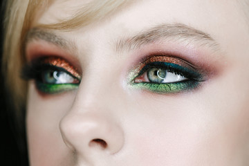 Obraz premium beautiful young model with green-brown smoky eyeshadow evening make up, perfect skin. Close-up face portrait