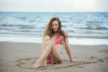 Fototapeta na wymiar sexy beautiful woman on beach summer vacation in bikini sitting on sand in holiday.