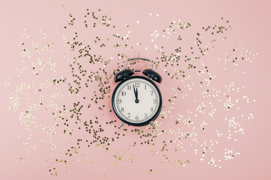 New Year concept. Alarm clock with golden confetti