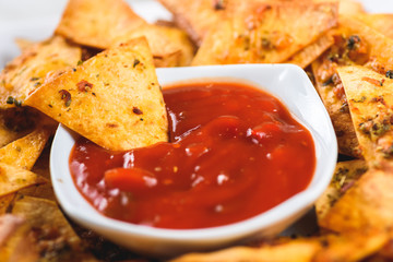 nachos and a bowl of spicy sauce