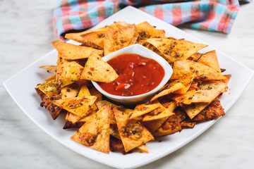 nachos and a bowl of spicy sauce