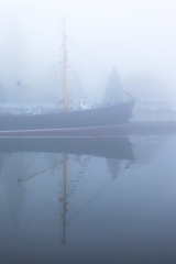 Fototapeta premium ship at the pier on the river in a thick dense fog