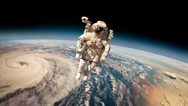 Astronaut in outer space against the backdrop of the planet earth. Typhoon over planet Earth. Elements of this image furnished by NASA.
