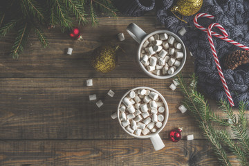 Winter party concept  with hot chocolate, two with cocoa cups with marshmallow on wooden table with christmas decorations, top view layout copy space