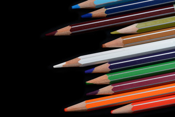 A pack of multicolored pencils on a dark background close up	