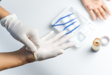 Woman doctor hands wearing gloves to clean the wound on the boy's palm