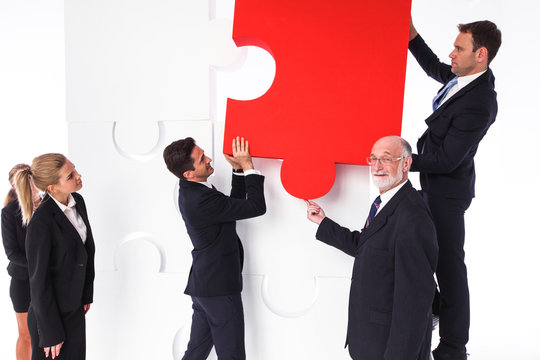 Business team assembling big puzzle