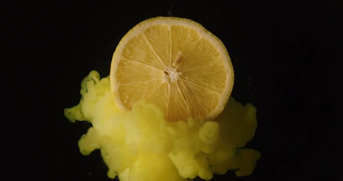 Explosion effect of colors on a lemon frying in the air on a black background. Concept: fruit, colors, special effect