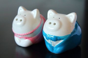 Beautiful porcelain pigs on a black wooden table. Close-up. Background.