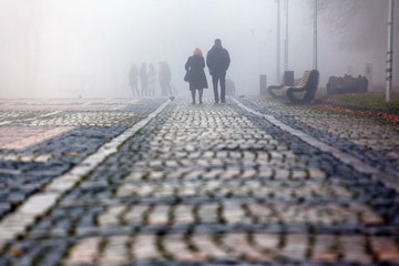 silhouettes of people in a strong dense fog