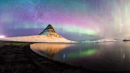 Colorful Aurora Borealis or better known as The Northern Lights and winter milky way over...