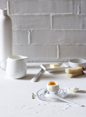 Traditional morning breakfast, boiled eggs, butter, bread, milk, on a white background, modern style