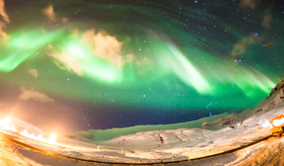 Colorful Aurora Borealis or better known as The Northern Lights and winter milky way over Kirkjufell, Iceland