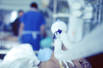 Blurred figures of male medical workers on the background of critical patient with an ET tube