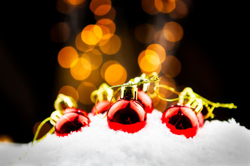 Christmas balls in the snow with golden bokeh