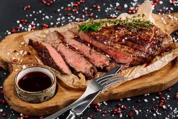 Beef rump steak from marble beef medium rare with sauce on wood plate, close-up. Selective focus.