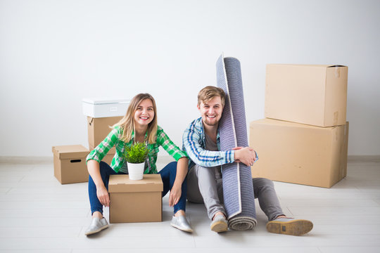 Relocation, real estate and moving concept - young couple people moved to a new apartment