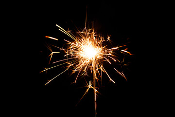 Symbols of the New Year on a dark background. New year party sparkler on black background.