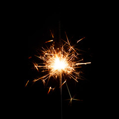 New year sparkler candle isolated on black background. Party backdrop.
