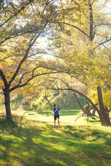 Fototapeta premium The girl runs through the autumn park.