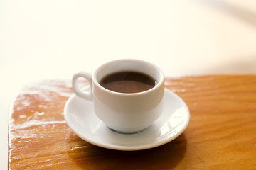 soft focus white coffee cup on a wooden table natural morning light vintage toned