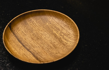 Wooden dish on the black table
