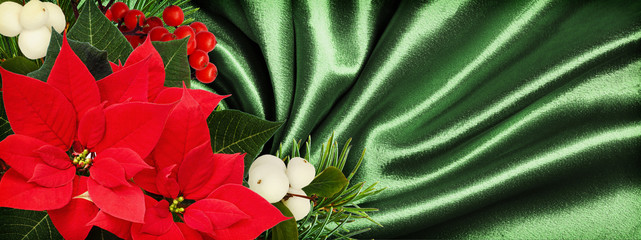 Christmas arrangement with red poinsettia flowers on green satin