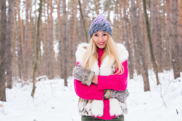 Fashion, winter and people concept - Young attractive woman dressed in fur waistcoat over snowy...