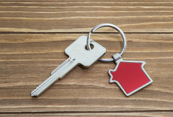 key chain with house symbol and keys on wooden background,Real estate concept