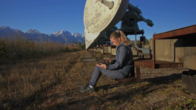 Woman student operator of institute of Solar Terrestrial Physics monitors communication equipment in notebook. Unique array solar radio telescope. Sun Solar Radio Telescope. The 'Quasar' observatory