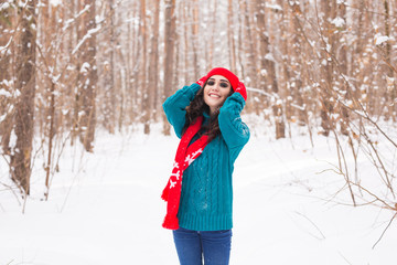 Fototapeta na wymiar Beautiful young woman walking in the winter snowy nature