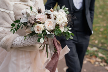 delicate wedding bouquet with cotton in the hands of the bride