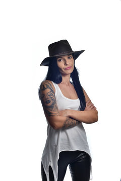 Dark long haired girl wearing a cowboy hat and a sleeveless white shirt posing isolated on white.
