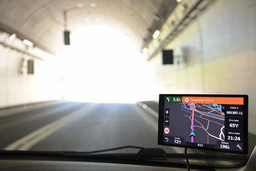 The car leaves the tunnel. The navigator is located on the front window of the car indicating the way to the driver during the journey.