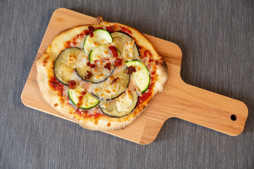 Aerial view of a pizza with zucchini, eggplant and dry tomatoes with gratin mozzarella cheese