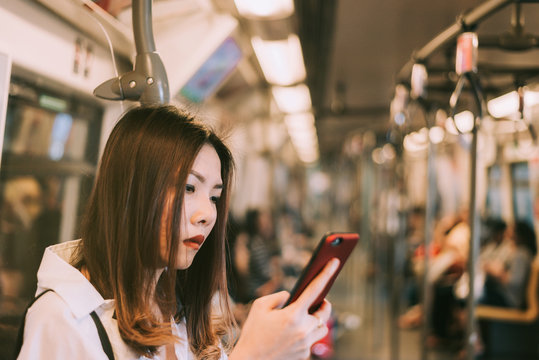 Business woman in subway using smartphone,Woman working on smart phone while traveling by train. Business travel concept.