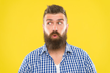 Obraz premium Man bearded hipster wondering face yellow background close up. Guy surprised face expression. Hipster with beard and mustache emotional surprised expression. Rustic surprised macho. Surprising news