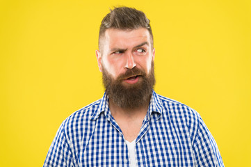 Obraz premium Sounds tricky. Man serious face raising eyebrow not confident. Have some doubts. Hipster bearded face not sure in something. Doubtful bearded man on yellow background close up. Doubtful expression