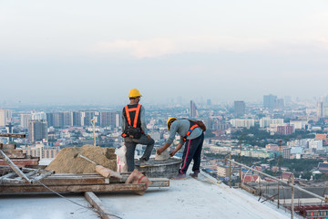 Construction worker is working on high building, bangkok, thailand