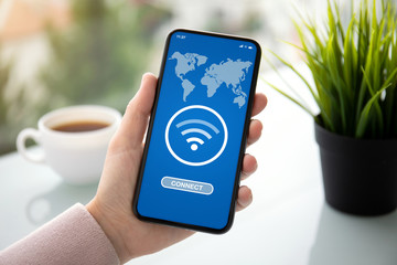 female hand holding phone with app wifi connect on screen