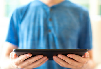 Young man with a tablet computer in a bright interior room