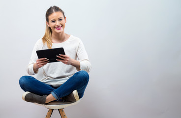 Young woman with a tablet computer on a gray background