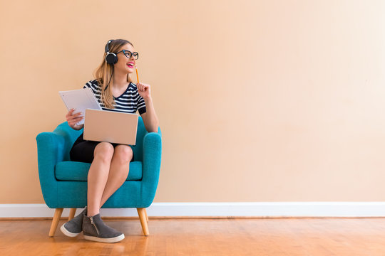 Young woman studying on her laptop computer in a chair