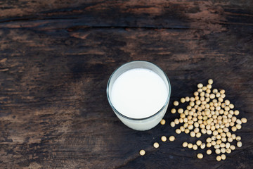 Soy milk and soy bean on wooden table and dark rustic kitchen background. Alternative milk concept.  selective focus