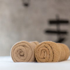 brown towels rolls on bed sheet in the hotel.