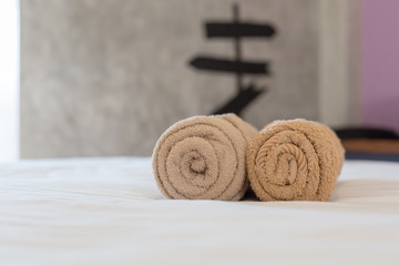 brown towels rolls on bed sheet in the hotel.